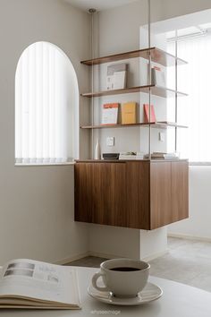 a cup of coffee sitting on top of a saucer next to a book shelf