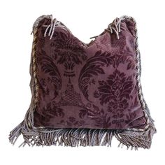 a purple pillow with tassels on it