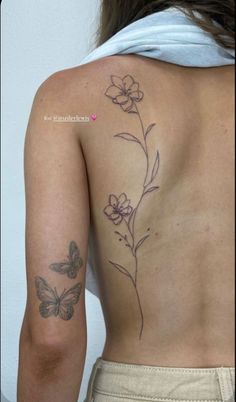 a woman's back with flowers and butterflies on it