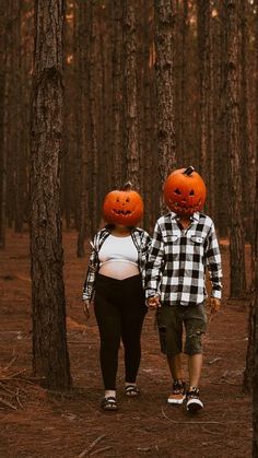 two people with pumpkin heads walking through the woods