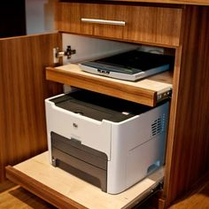 an open drawer with a computer and printer in it