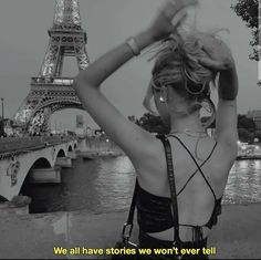 a woman standing in front of the eiffel tower with her hands on her head