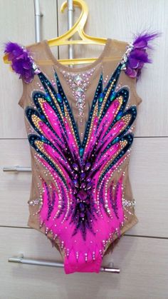 a leotard with feathers and sequins on the back is hanging in front of a door