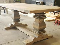 a wooden table sitting on top of a cement floor next to other woodworking tools