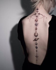 the back of a woman's neck with planets and stars on it