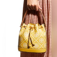 Yellow Tory Burch Bucket Bag. Height 4.8 Inches. Depth 8.4 Inches. Yellow Bucket Bag With Gold-tone Hardware, Elegant Yellow Bucket Bag With Removable Pouch, Elegant Yellow Bucket Bag With Detachable Strap, Yellow Bucket Bag For Travel, Designer Yellow Pouch Bag, Elegant Yellow Bucket Bag, Luxury Yellow Bucket Bag With Removable Pouch, Chic Yellow Pouch Bucket Bag, Elegant Yellow Bucket Bag For Travel