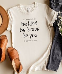 Rock this empowering "Be Kind, Be Brave, Be You" t-shirt and share a positive message with the world. This comfy tee is a reminder to embrace your unique self, spread kindness, and find your courage. It's the perfect gift for anyone who wants to inspire themselves and others. Welcome to my design haven! I offer an eclectic mix of styles and sizes. Whether you're into vintage vibes, trendy designs, or timeless classics, I hope you find it all here. Browse through pages of neatly designed shirts, each one beckoning you to touch and explore. This Shirt Is Bella + Canvas Brand: * Retail fit * Unisex sizing * Shoulder taping * Side-seamed * Tear away label * Pre-shrunk WASHING INSTRUCTIONS: Machine wash: warm (max 40C or 105F); Non-chlorine: bleach as needed; Tumble dry: low heat; Iron, steam o Kind To Yourself, Kindness Quotes For Shirts, Be Kind T Shirt, Be Kind Boys Shirt, Choose Kind Shirt, Be Kind. Shirt, Inspirational Tees, Spread Kindness, Positive Messages