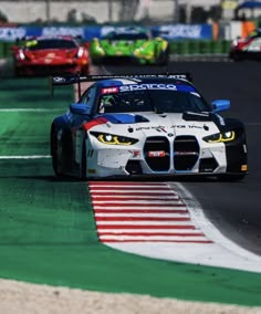 two cars racing on a race track during the day