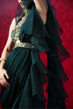 Introducing the stunning Lara Ruffle Saree – a true masterpiece of traditional Indian design and modern sophistication! This beautiful saree features a dark green chiffon and organza ruffled pre-draped saree, paired with a hand-embroidered blouse and waist belt.
The intricate hand embroidery on the blouse and waist belt showcases the impeccable craftsmanship and attention to detail that goes into every piece. The flowing chiffon and organza fabric of the saree creates a sense of grace and moveme Bollywood Style Ruffled Organza Pre-draped Saree, Elegant Pre-draped Chiffon Saree, Elegant Organza Saree With Ruffles, Elegant Festive Dupatta With Ruffles, Elegant Organza Dupatta With Ruffles, Evening Organza Saree With Ruffles, Festive Chiffon Saree With Ruffles, Elegant Organza Pre-draped Saree With Ruffles, Elegant Pre-draped Ruffled Organza Saree