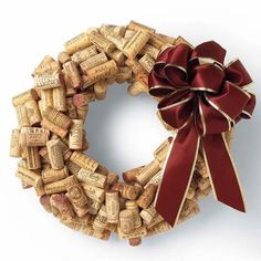 a close up of a wreath made out of wine corks with a red bow