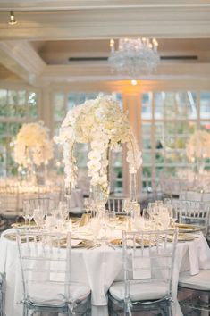 the tables are set with white flowers and place settings