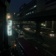 a city street at night with cars and buses