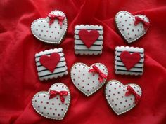 decorated cookies in the shape of hearts on a red cloth