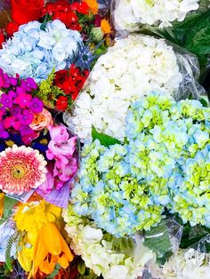 many different colored flowers are laid out together