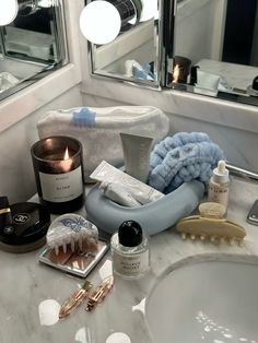 a bathroom sink with toothbrushes, soap and other items on it