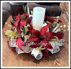 a candle is sitting on top of a table with red and white flowers in it