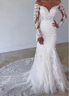 a woman in a white wedding dress with long sleeves and an off the shoulder lace top