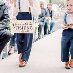 two young boys wearing suspenders are walking down the aisle