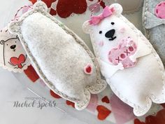 two stuffed animals sitting on top of a plate next to each other with hearts around them