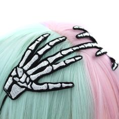 "Make a bold and dramatic statement with our Skeleton Hands Headband. This unique accessory features two skeletal hands clasping over the top of your head, with wired fingers that can be shaped to suit your style. Embroidered with precision using a design crafted and digitized by me, this headband ensures high-quality detailing. The elastic cord is securely sewn on, providing a comfortable and secure fit. Whether you're into gothic fashion or simply appreciate distinctive accessories, this headband adds an edgy and artistic touch to your look. Stand out from the crowd with this uniquely crafted headpiece that combines craftsmanship and creativity. Other colors available in my shop. ♥ Measures approx. 6.5\" across x 3\" high ♥ Designed by & exclusive to Kawaii Hair Candy ♥ Made in the USA ♥ Harajuku Style Adjustable Costume Accessories For Halloween, Punk Headband For Halloween Cosplay, Adjustable Black Punk Hair Accessories, Adjustable Gothic Hair Accessories For Halloween, Punk Headband For Halloween Costume Party, Punk Style Headband For Halloween Costume Party, Punk Black Hair Accessories For Halloween, Halloween Punk Black Hair Accessories, Punk Halloween Headband Costume Accessory