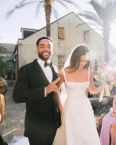 a man and woman in formal wear standing next to each other at a wedding ceremony