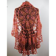 an orange crocheted shawl on a mannequin