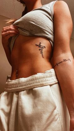 a woman with a cross tattoo on her stomach