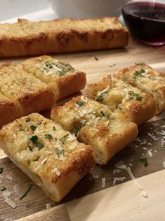 several pieces of bread on a cutting board with parmesan sprinkles