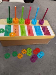 a box filled with colorful legos on top of a cement floor next to other toys