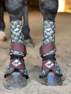 the legs of a horse wearing boots with flowers on them