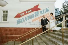 a bride and groom walking down the stairs to their wedding reception