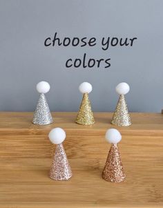 four small gold and silver cones with the words choose your colors written on them in black