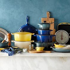 many different colored pots and pans on a counter