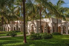 a large white building surrounded by palm trees