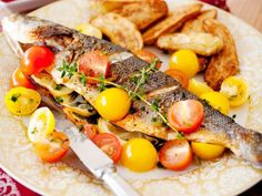 fish with tomatoes and lemons on a plate