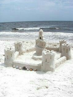 a sand castle sitting on top of a sandy beach