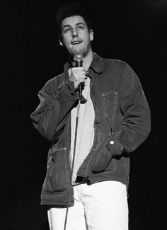 a black and white photo of a man holding a microphone