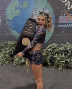 a female cheerleader posing with her trophy