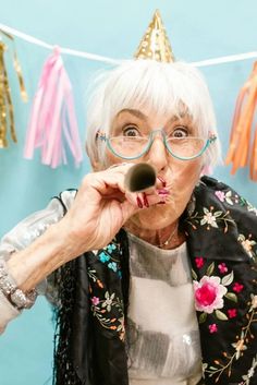 an older woman blowing bubbles on her nose