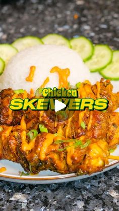 chicken skewers on a plate with rice and cucumbers