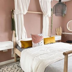 a bedroom with pink walls, white curtains and a bed in the middle is decorated with various colored pillows