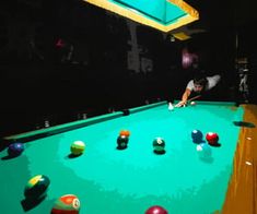 a man is playing pool in a dark room with several balls on the table and one person leaning over