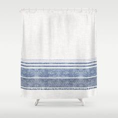 a white shower curtain with blue stripes on it