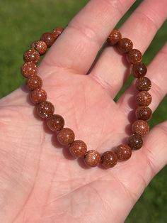 This sparkling bracelet is made with gorgeous goldstone beads. Each bead shimmers elegantly as the bracelet moves in the light. Intentions of joy, grounding, and self-reflection pair well with goldstone jewelry. The bracelet is double strung for durability, stretches for your comfort, and stacks nicely with other bracelets. Goldstone (also called sandstone) is a stone of ambition and joy. It is a type of glass and has reflective properties to help you see your authentic self more clearly. Goldstone is a very warm stone, encouraging you to fill your cup while simultaneously grounding you. *Information for metaphysical purposes only - Goldstone beads, ~7.6-7.9mm *Note: Goldstone is a man-made stone. - Beading string Items are packed with care and sent straight to your door. Thank you for vis Sparkling Beaded Bracelets As Gift, Gold Crystal Bracelet With 8mm Beads For Party, Sparkling Beaded Bracelets For Gifts, Sparkling Round Bead Bracelets For Gifts, Sparkling Round Beads Crystal Bracelet As Gift, Sparkling Round Beads Crystal Bracelet For Gift, Sparkling Crystal Bracelet With Round Beads For Gift, Sparkling Crystal Bracelet With Round Beads As Gift, Sparkling Adjustable Beaded Bracelets As Gift