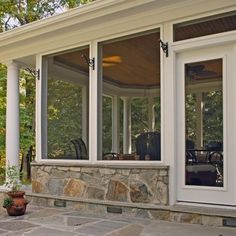 a stone patio with white columns and windows