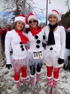 three women dressed up as snowmen in costume for a race event, posing for the camera