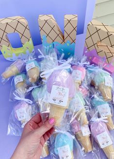 ice cream cones wrapped in plastic bags and labeled with the word love are being held by a woman's hand