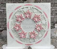 a white card with pink flowers and the words winter wishes written on it, in front of a brick wall