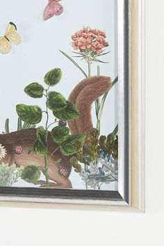 a painting with flowers and butterflies on the wall next to a framed photo in a frame