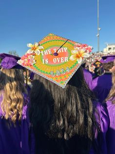 a group of graduates in purple caps and gowns stand together at the graduation ceremony